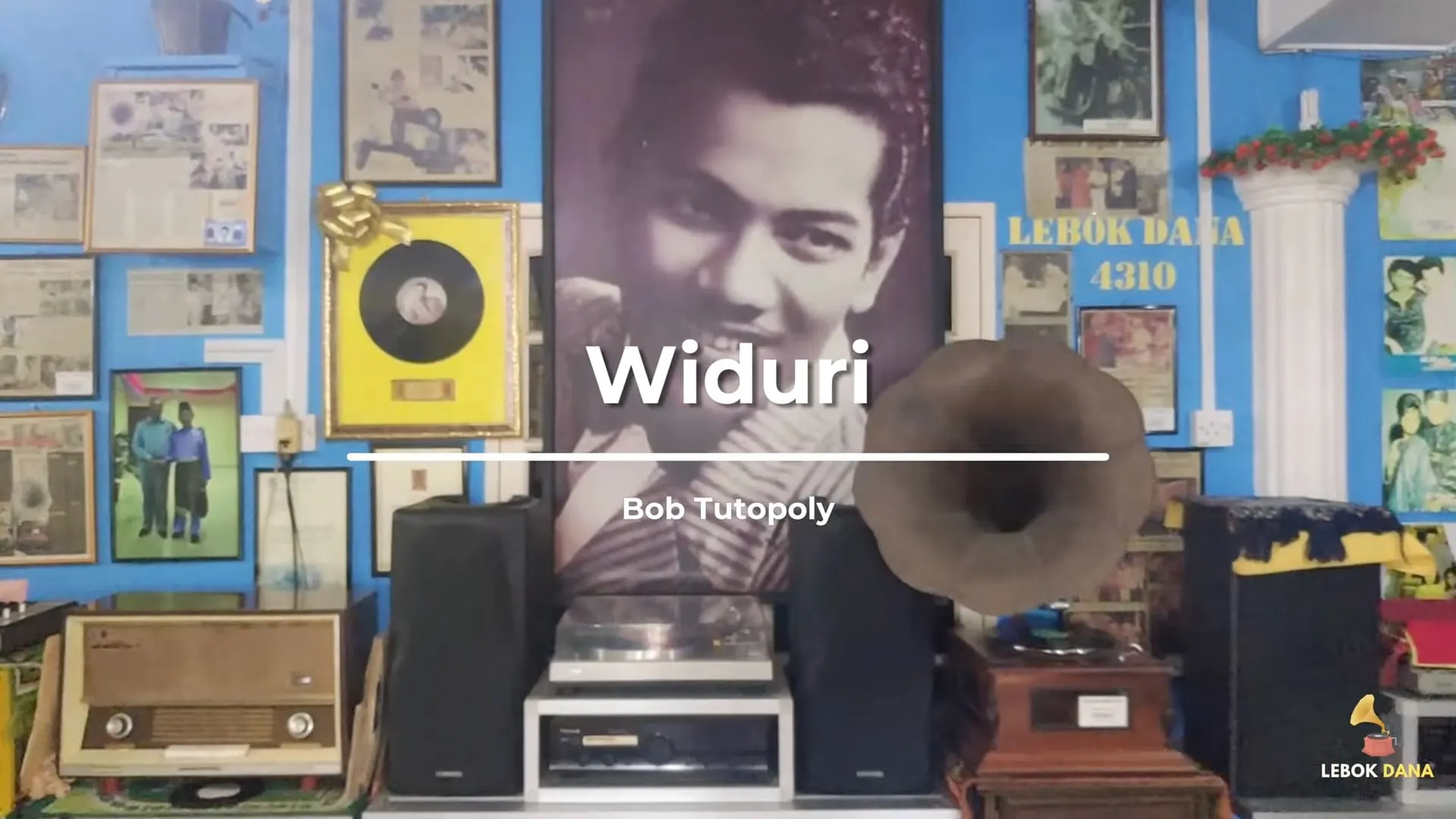 Kad tajuk video Widuri nyanyian Bob Tutupoly, berlatarkan dinding Galeri Lebok Dana dengan potret P. Ramlee, piring hitam berbingkai dan gramofon